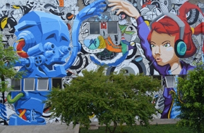 Grafite na parede de um edifício mostrando uma mulher com fone de ouvido