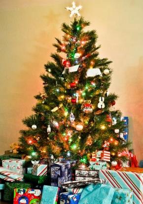 Árvore de Natal decorada com presentes ao seu lado