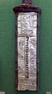 Foto de uma parte de uma espada de metal com figuras