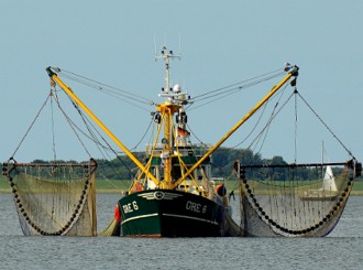 Foto de um barco de pesca com grandes redes de pesca nas laterais.