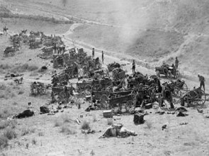 Foto em preto e branco de canhões e munições sendo transportados por soldados