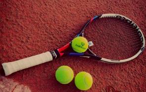 Uma raquete e três bolas verdes de tênis de quadra