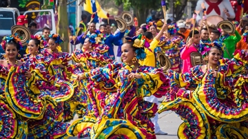 Imagem de pessoas desfilando com fantasias no Carnaval de Barranquilla