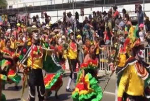 Imagem de pessoas desfilando com fantasias no Carnaval de Barranquilla