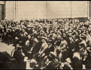 Foto antiga mostrando muitas pessoas reunidas e sentadas