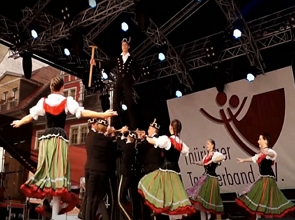 Foto de homens e mulheres dançando com roupas típicas alemãs