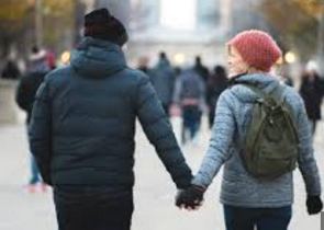 Casal andando de mãos dadas num dia de frio