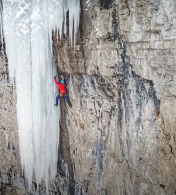 Foto de uma pessoa escalando uma montanha
