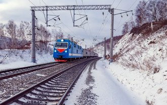 Ferrovia Transiberiana Foto de um trem passando pela ferrovia transiberiana com cenário de vegetação coberta por neve
