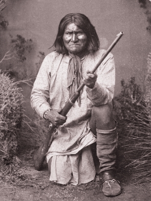 Foto antiga do líder indígena apache com uma arma de fogo na mão