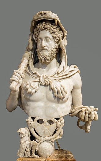Cômodo Escultura branca de um busto de um homem de barba e bigode com um bastão na mão e uma espécie de capuz em formato de um animal felino.