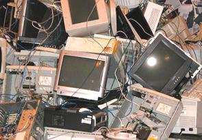 Foto mostrando monitores e computadores num depósito de lixo