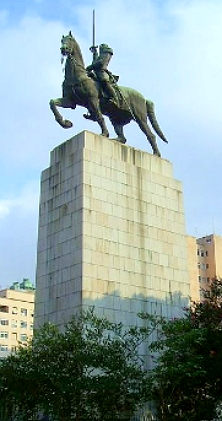 Escultura de um homem montando um cavalo e com espada erguida