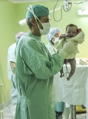 Foto de um obstetra após o parto com um bebê