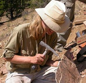 Foto de uma paleontóloga trabalhando num local com fósseis.