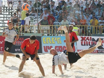 Foto de jogadores participando de uma partida de futebol de areia Foto de jogadores participando de uma partida de futebol de areia
