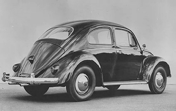 Foto de um autom&oacute;vel fusca de forma arredondada e de cor escura