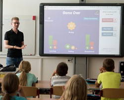 Foto de um professor com alunos numa sala de aula