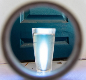 Foto de um copa com água atrás de uma porta