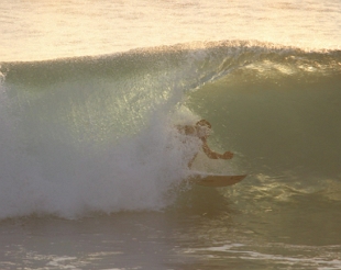 Foto de um surfista dentro de um tubo formado pela onda