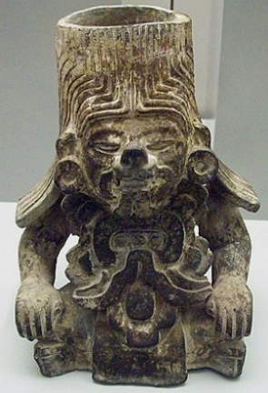 Foto de um vaso de cerâmica zapoteca com rosto humano e felino misturado